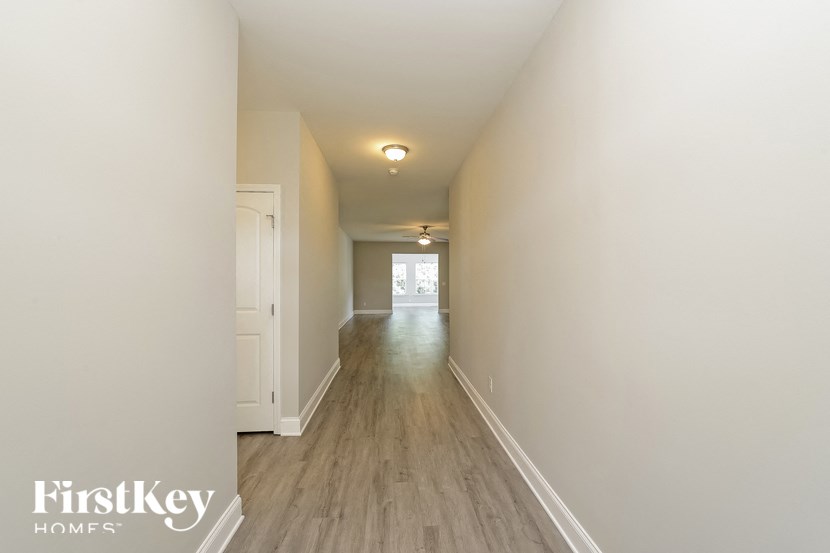 a long hallway with white walls and wood floors