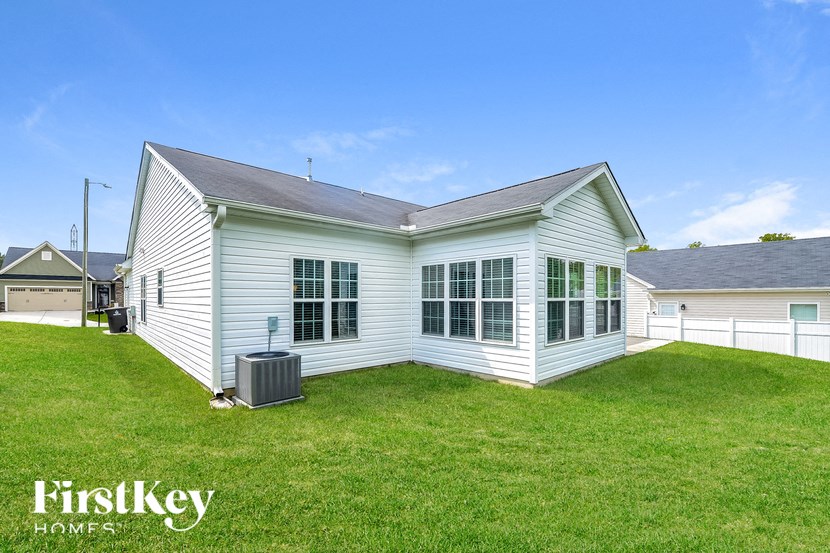 a small white house with a grassy yard in front of it