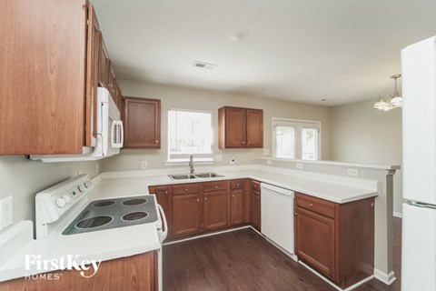A kitchen with wooden cabinets and a white stove top oven.