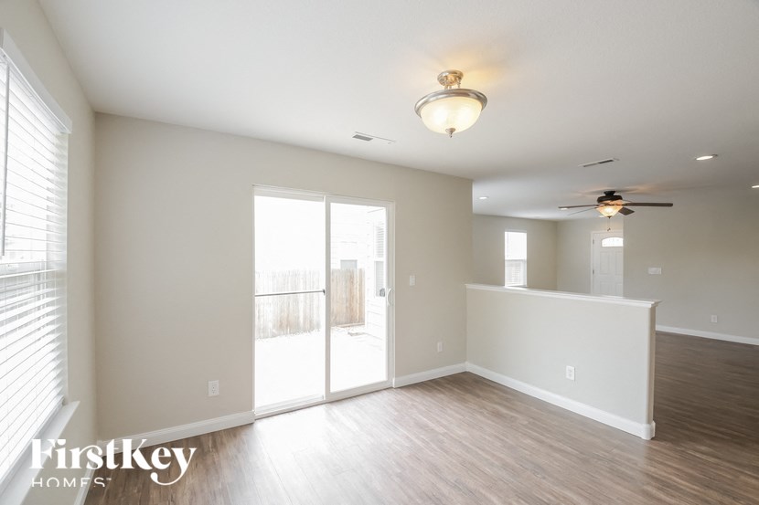 A room with a sliding glass door and a ceiling fan.
