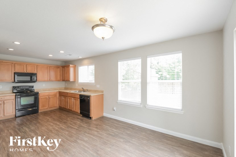 A kitchen with wooden cabinets and a black stove top oven.