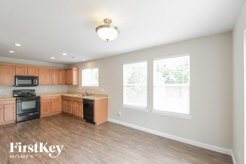 A kitchen with wooden cabinets and a black stove top oven.