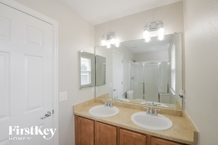 A bathroom with two sinks and a large mirror.