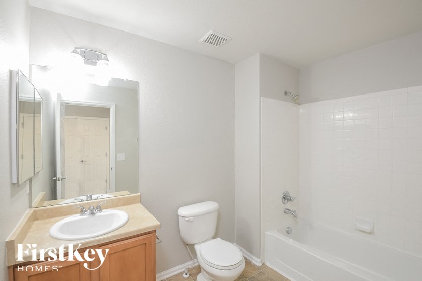 A white bathroom with a sink, toilet and bathtub.
