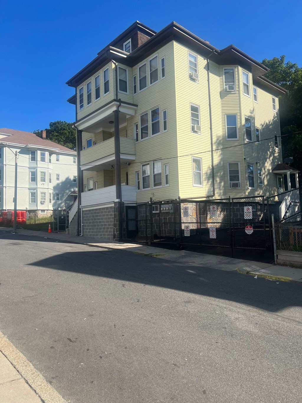 a large yellow house on the side of a street