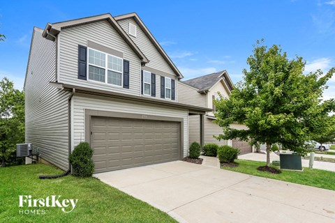 a gray house with a garage door and a driveway