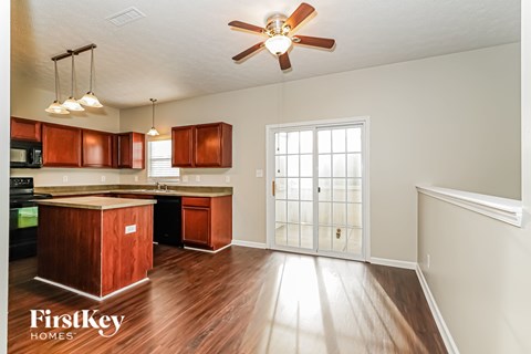 A kitchen with wooden cabinets and a brown island.