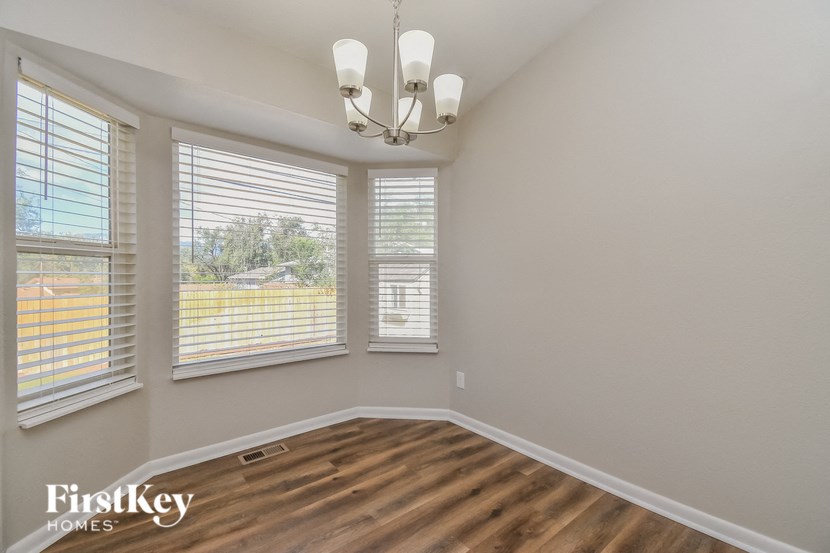 a living room with a chandelier and three windows