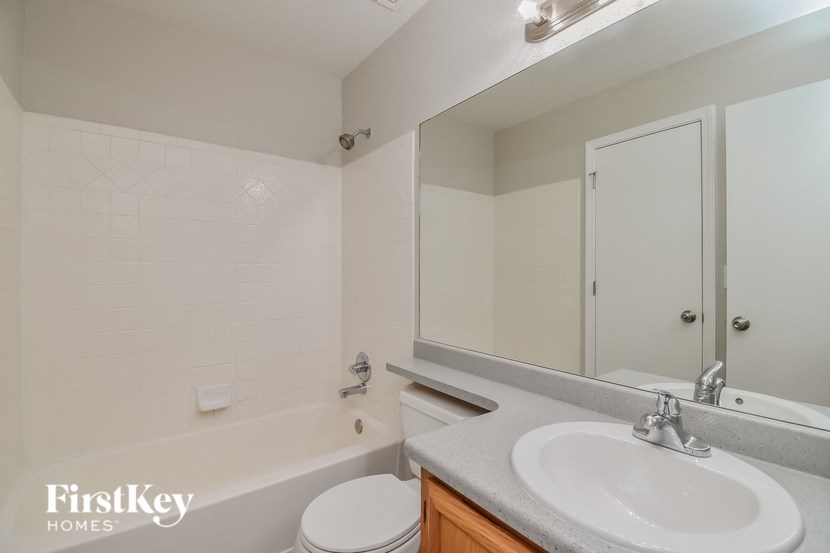 a bathroom with a sink toilet and tub and a mirror