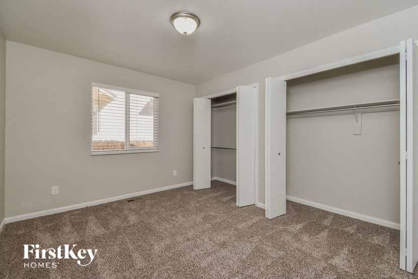 a bedroom with two closets and a window