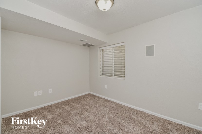 the spacious living room has carpeting and a window
