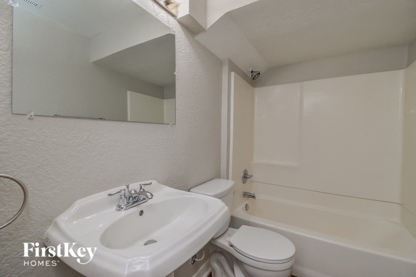 a white bathroom with a sink toilet and tub