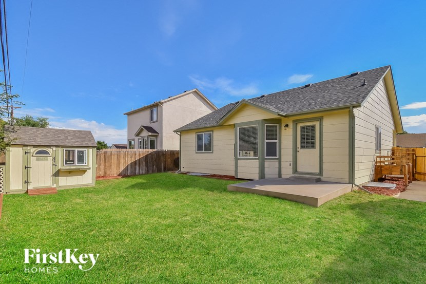 a backyard with a house and a yard and a fence