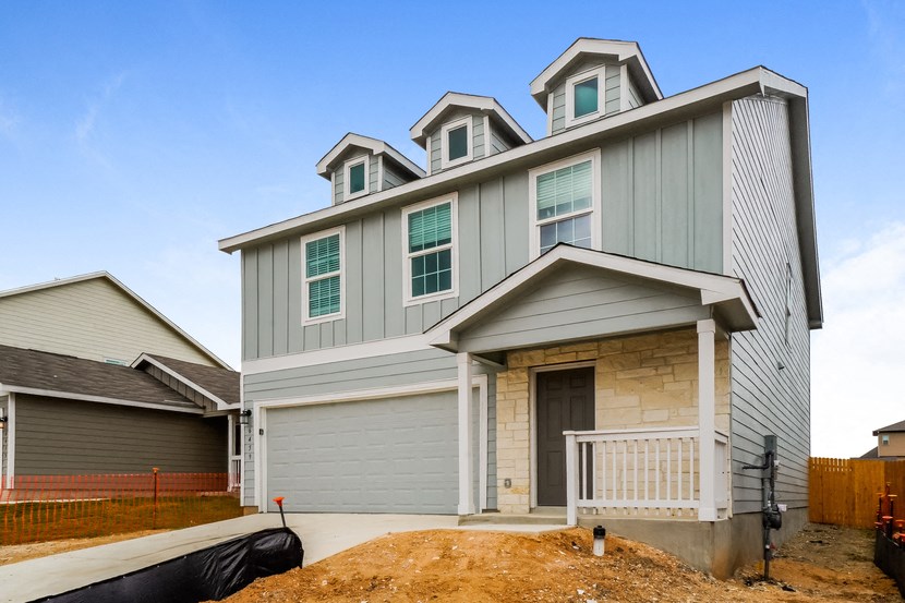a home being remodeled with a front porch and gray siding