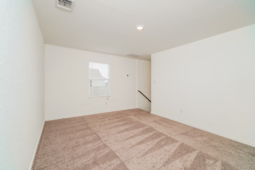 an empty living room with carpet and a window