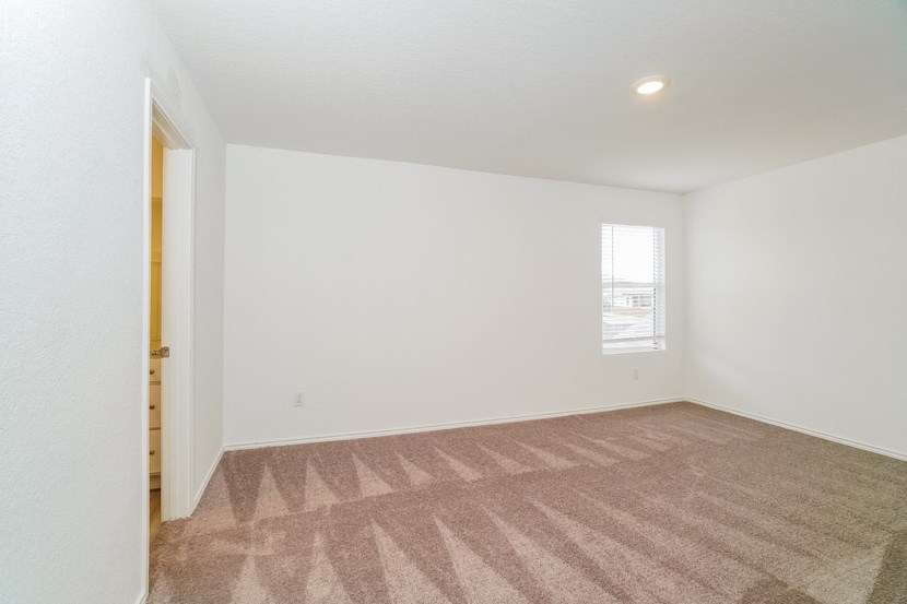 an empty living room with carpet and a window