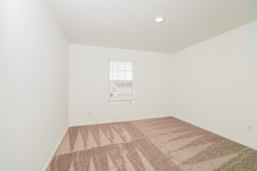 an empty room with carpet and a window