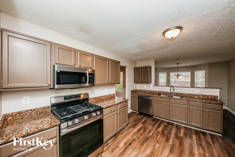 A kitchen with brown cabinets and a black stove top oven.