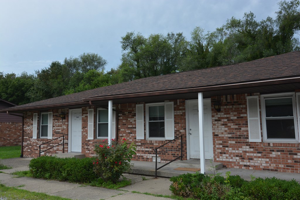 a brick building with white doors and a porch