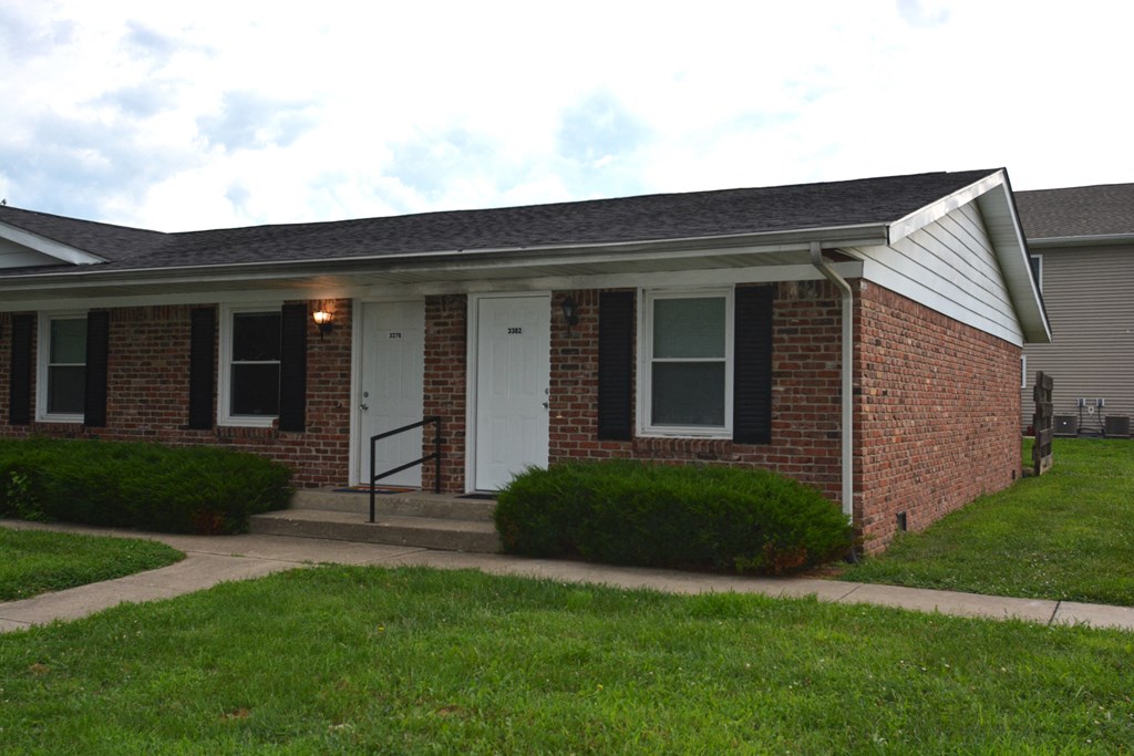 the front of a brick house with a porch