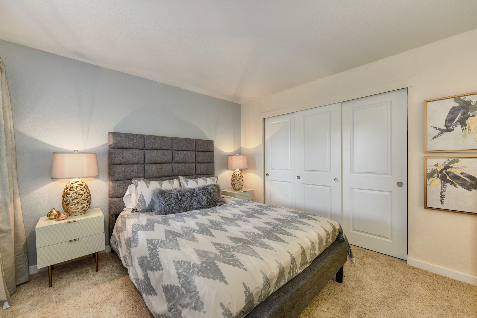 Bedroom with Large Closet, Carpet, Gray Bedframe, and White Bedside Dresser with Lamp at Rush River Apartments, California