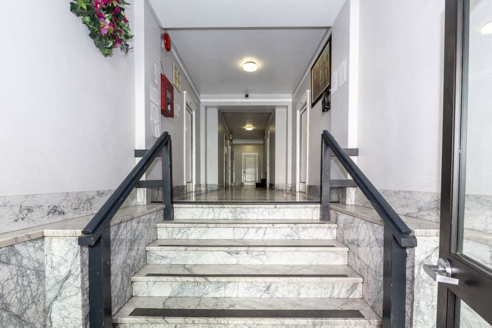 the lobby of a building with marble stairs and a door