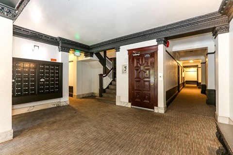 the lobby of a building with a hallway with doors and stairs