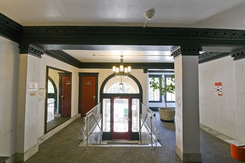 the lobby of a building with a staircase and a chandelier