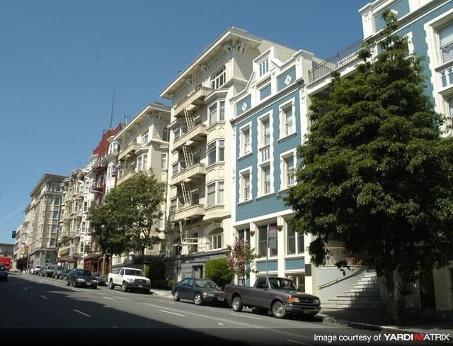 a city street with cars parked in front of a building