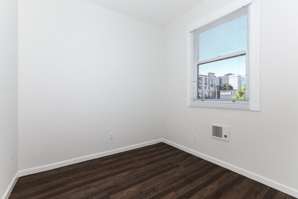 an empty room with white walls and a window