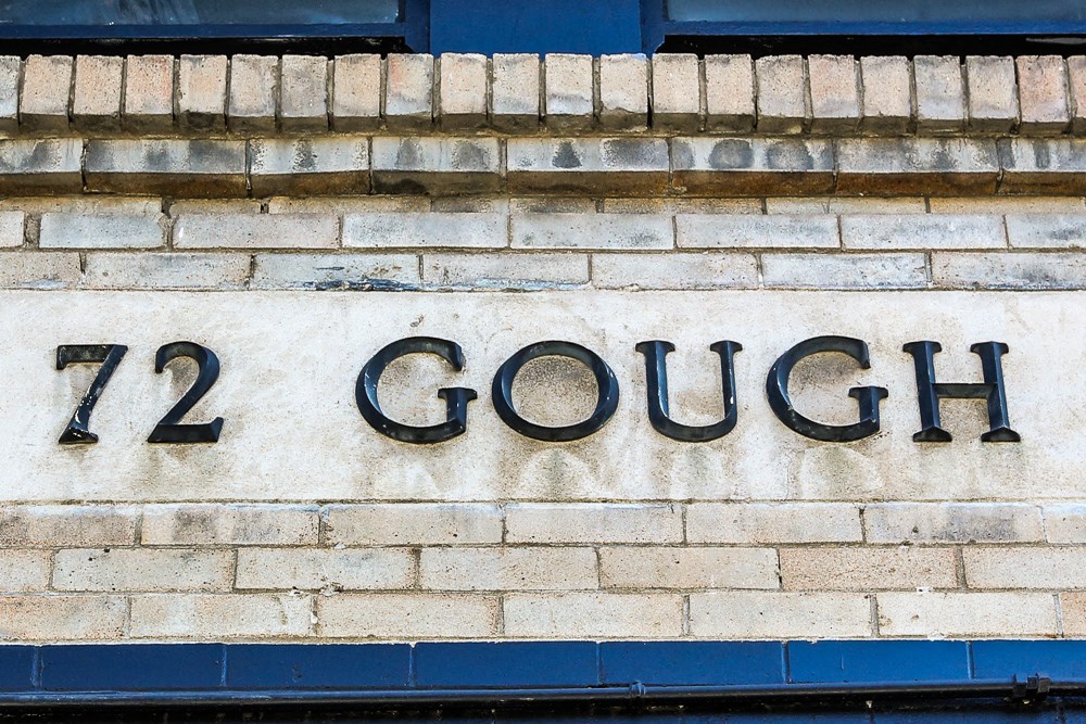 a sign on a brick wall that reads 112