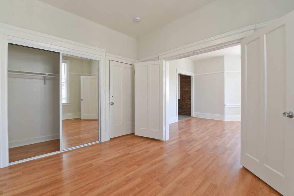 a living room with a hard wood floor and a closet