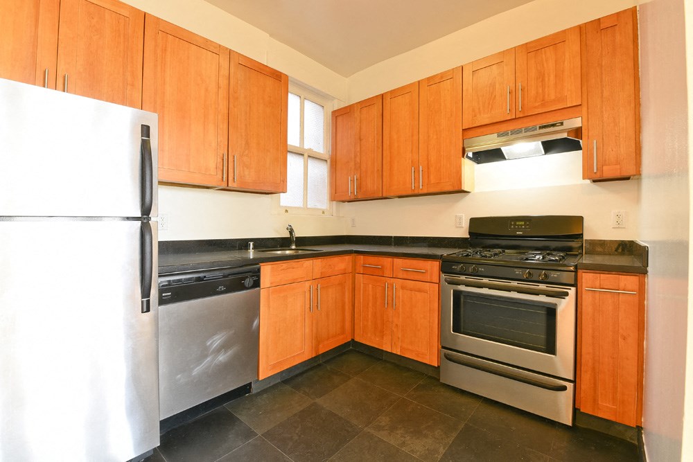 a kitchen with wooden cabinets and stainless steel appliances