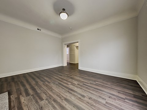an empty living room with wood flooring and white walls
