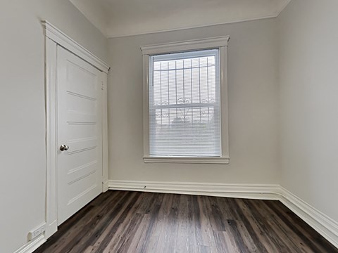 an empty room with wood floors and a window