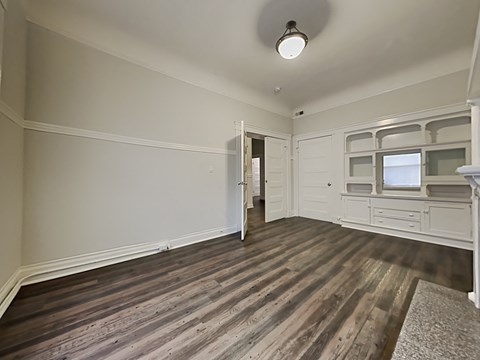 an empty living room with wood flooring and white walls