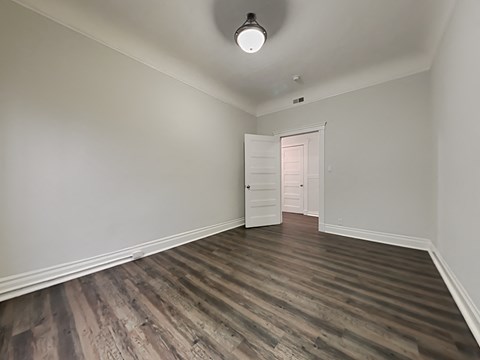 an empty living room with wood flooring and white walls