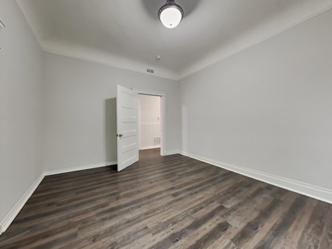 an empty living room with white walls and wood flooring