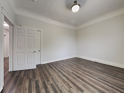 an empty living room with wood flooring and a white door
