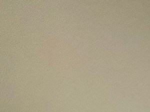 A room with a white ceiling, a window, a door, and a fire extinguisher on the wall.