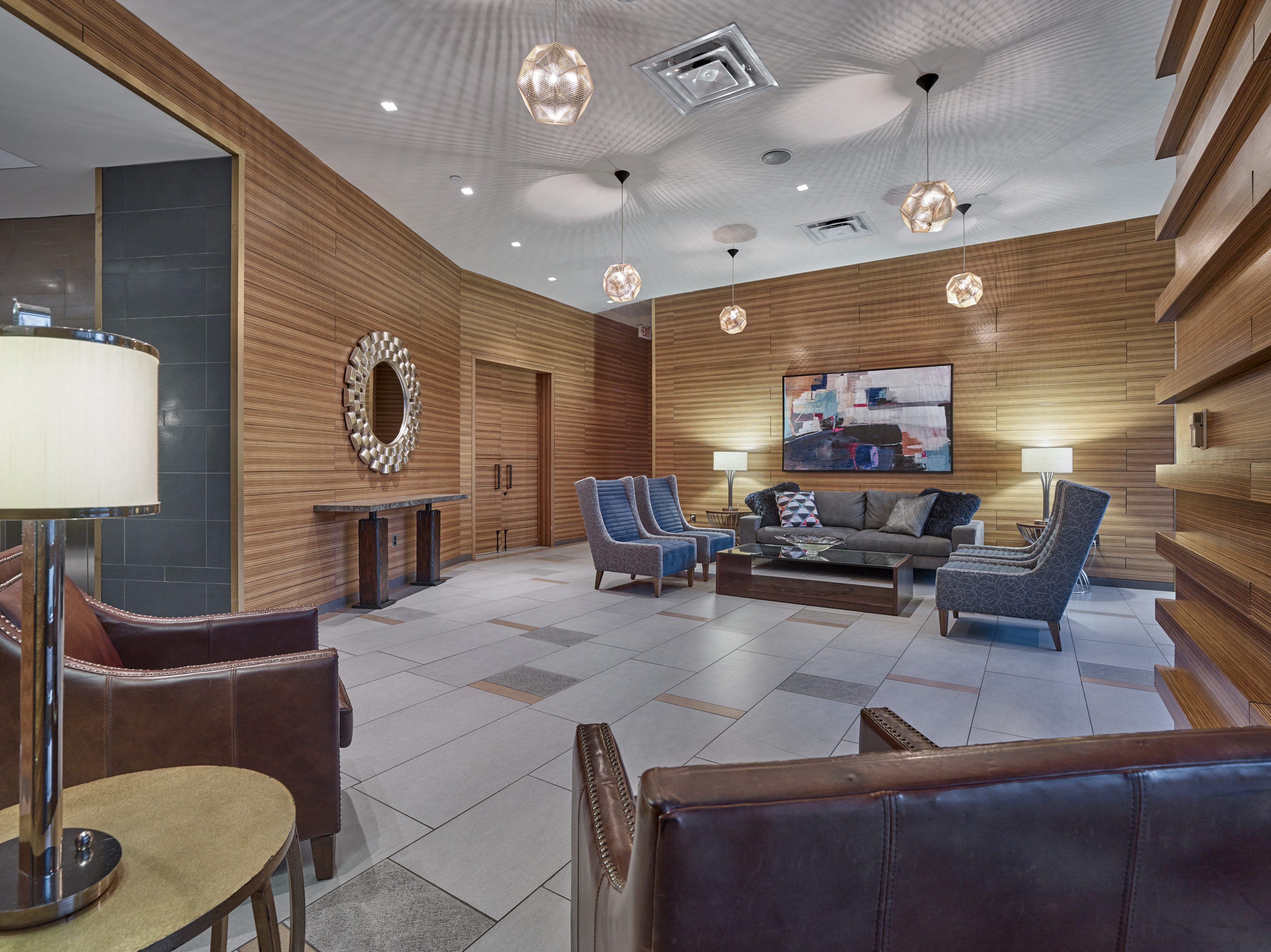 A living room with a brown couch and a TV on the wall.