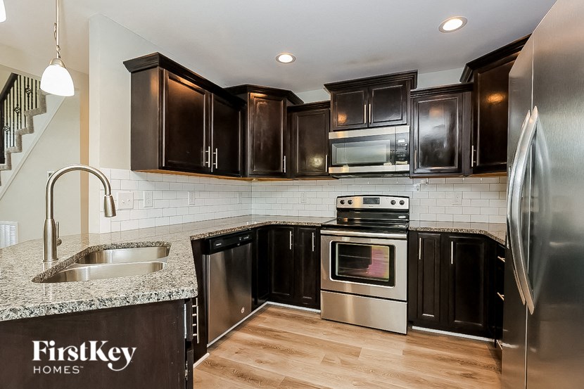 a kitchen with black cabinets and stainless steel appliances