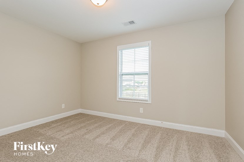 a bedroom with a carpeted floor and a window