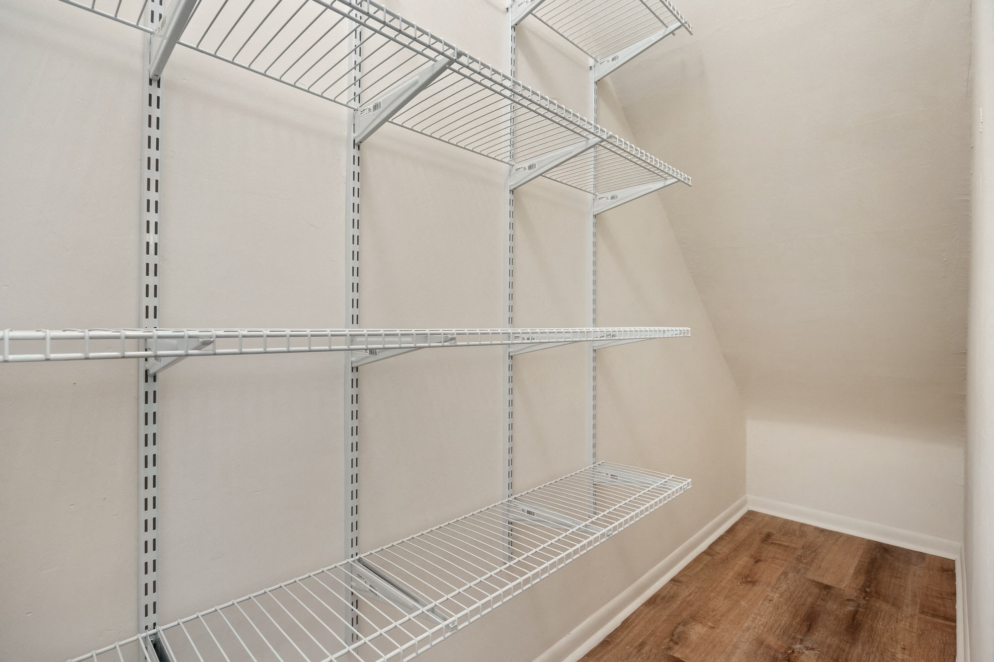 the walk in closet of a studio apartment with empty shelves
