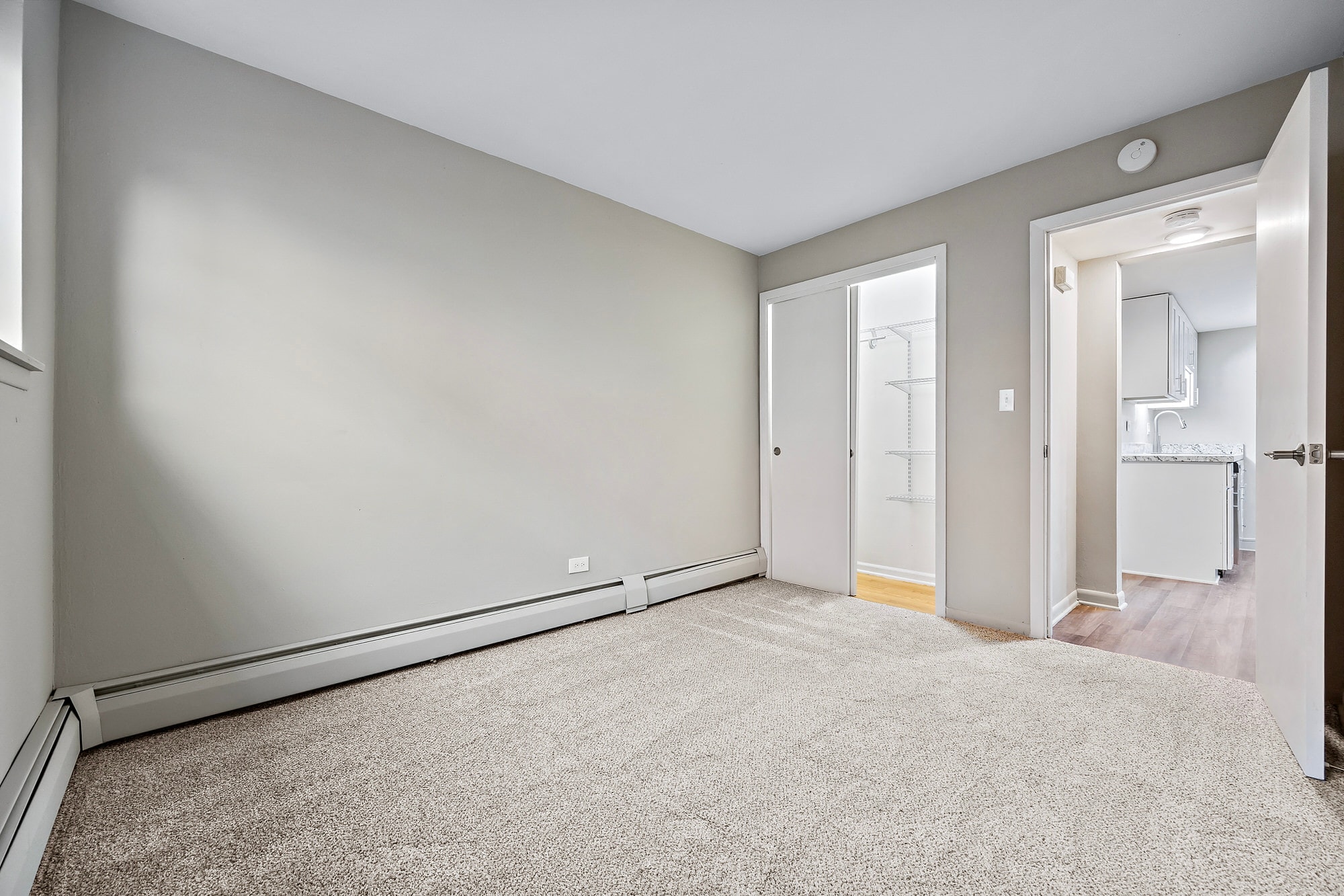 a living room with a carpeted floor and a door to a bathroom