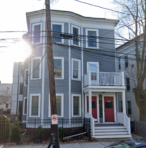 a blue house with a red door on a street