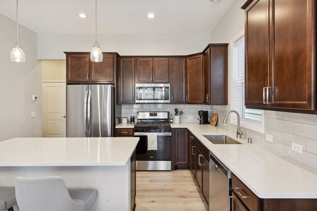 a kitchen with wooden cabinets and a white counter top