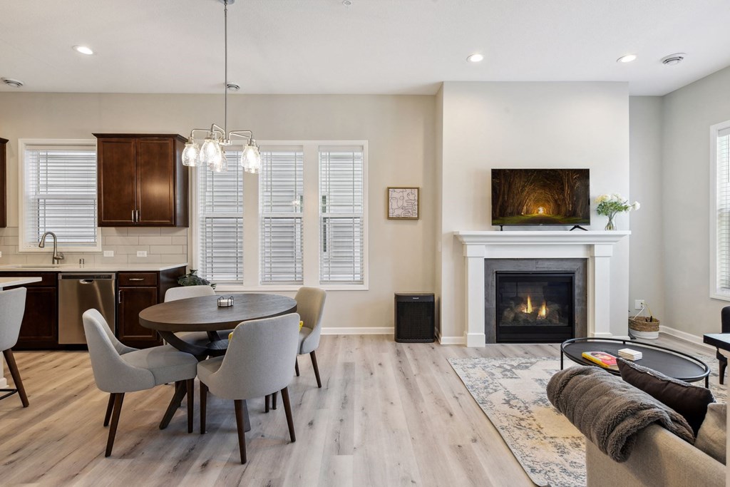 a living room with a fireplace and a table and chairs