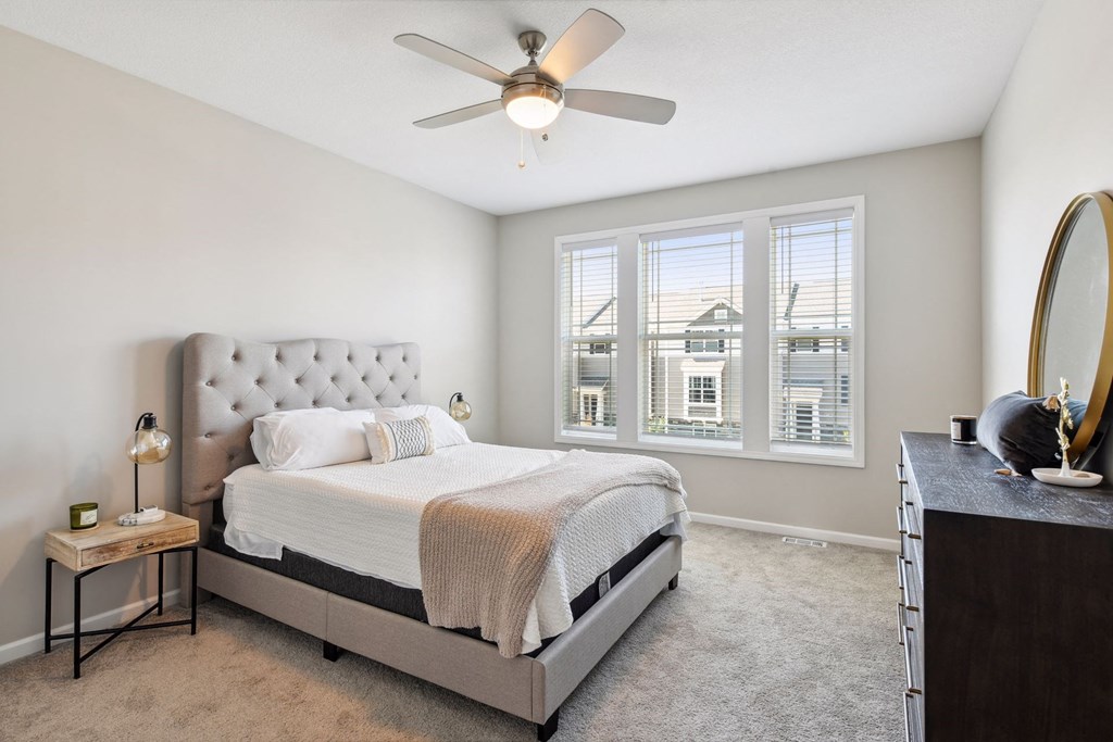 a bedroom with a bed and a ceiling fan
