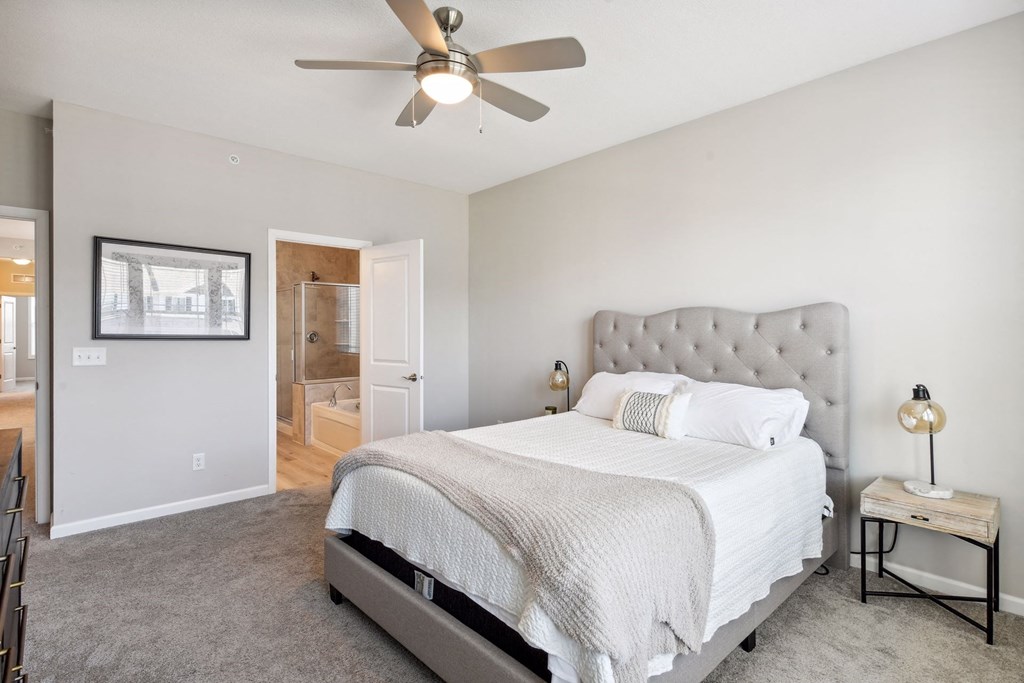 a bedroom with a bed and a ceiling fan
